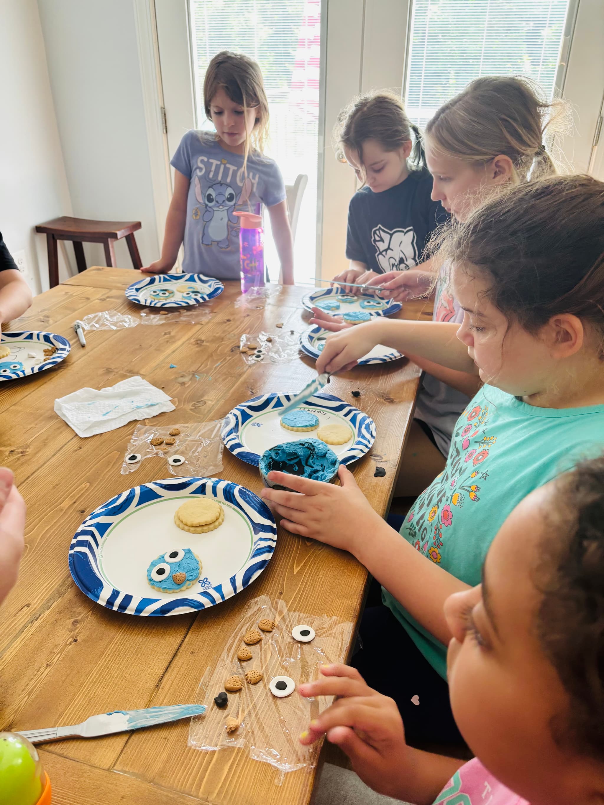 Campers decorating cookies at a Sweet Cake Factory class table.
