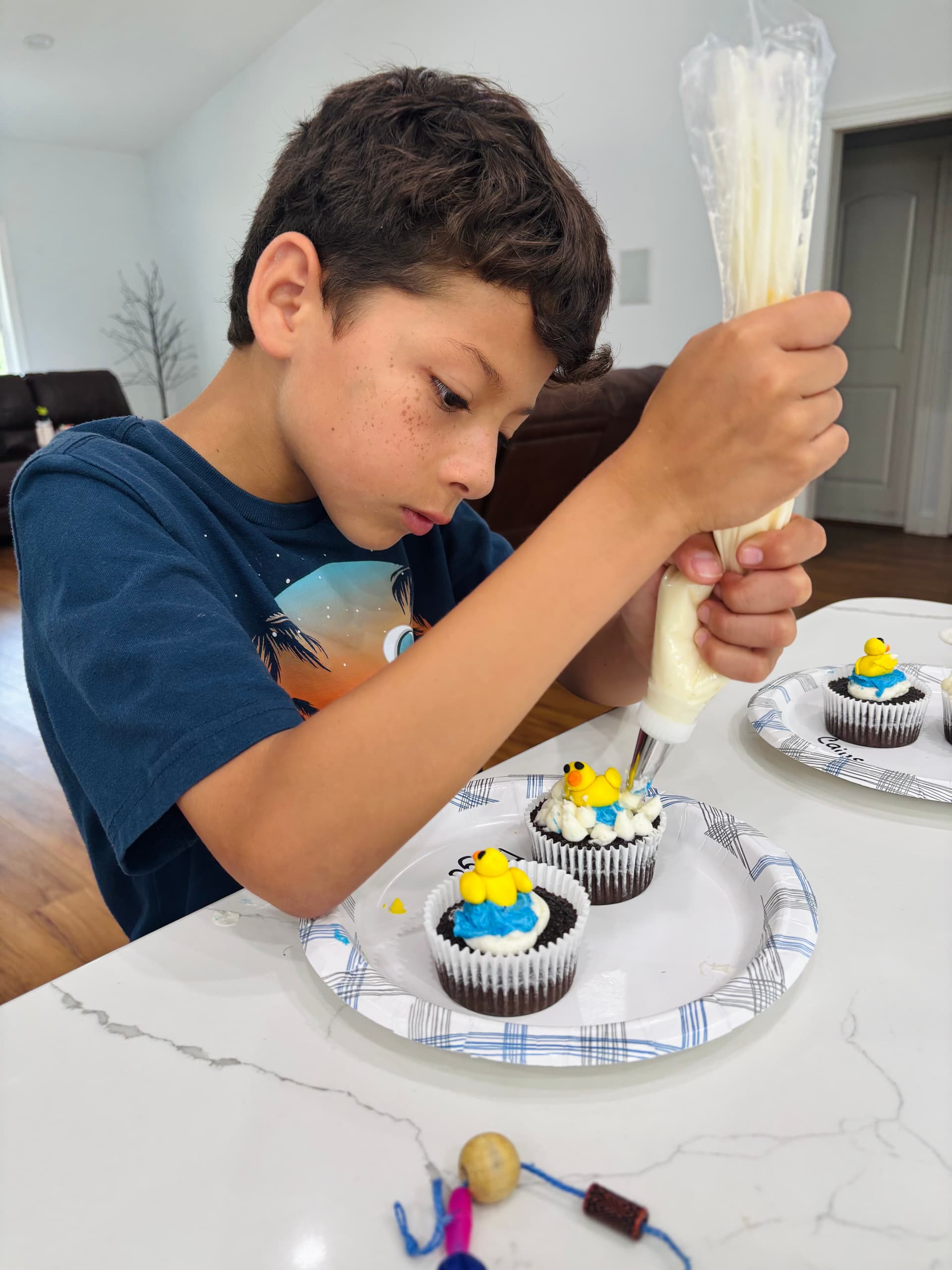Kids decorating cupcakes during Sweet Cake Factory summer baking camp.