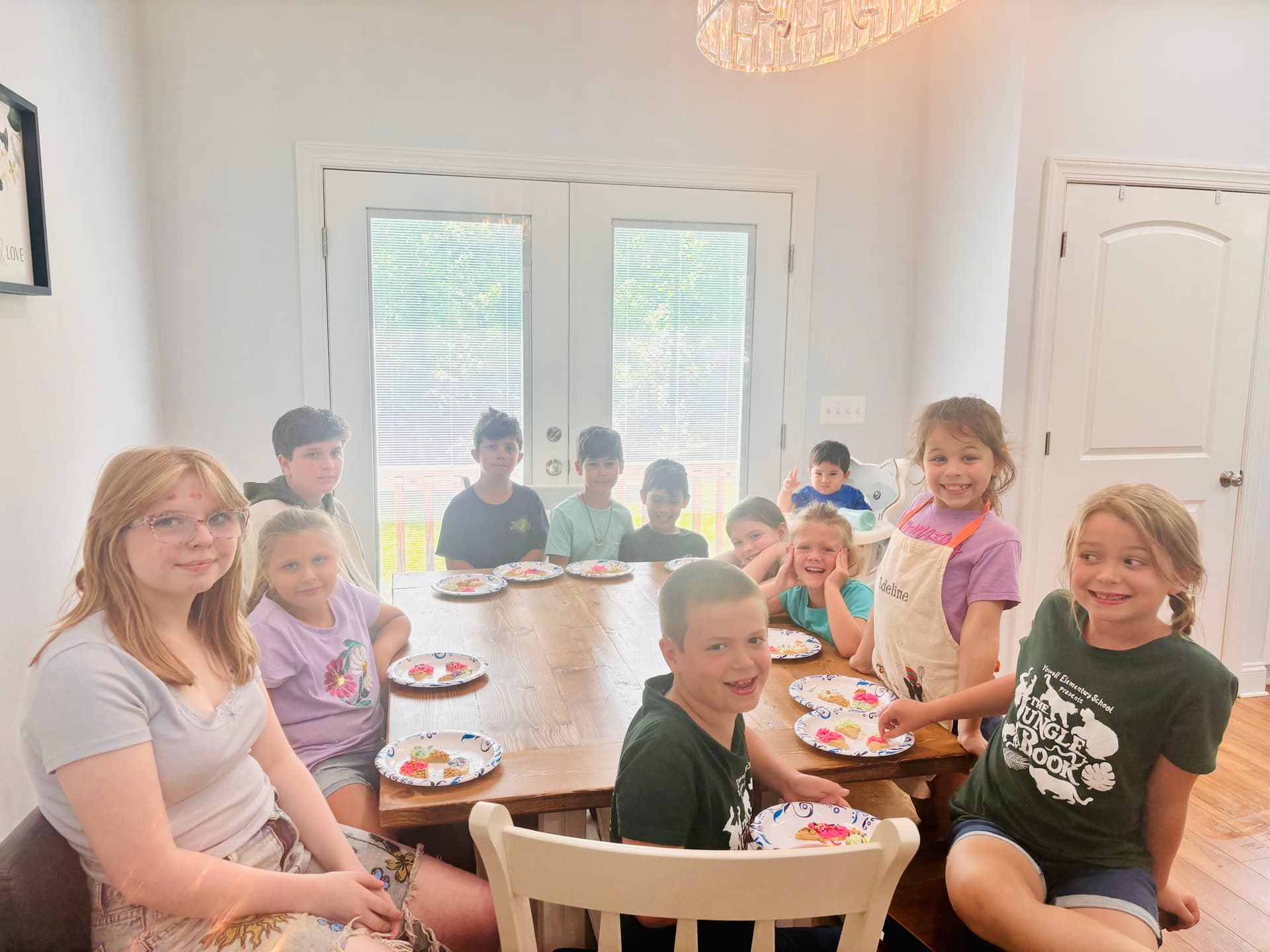 A group of campers smiling around a decorated cookie table.