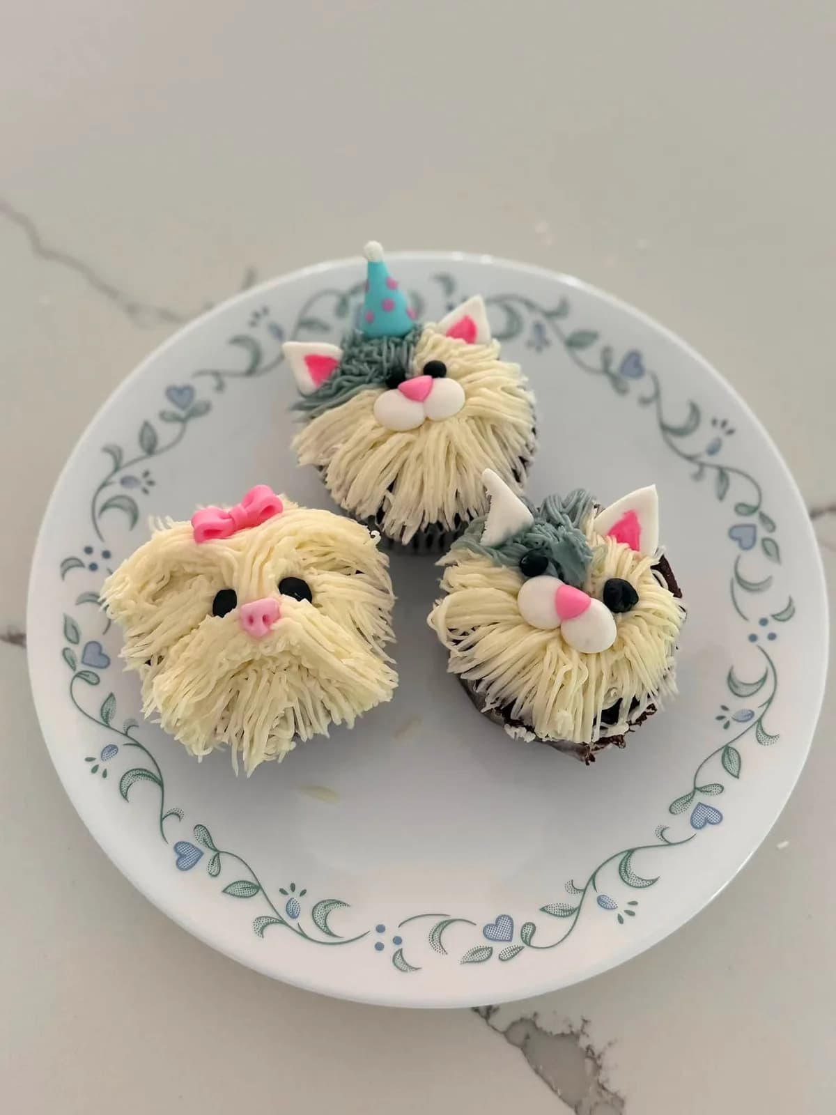 Three cupcakes with playful piped animal faces