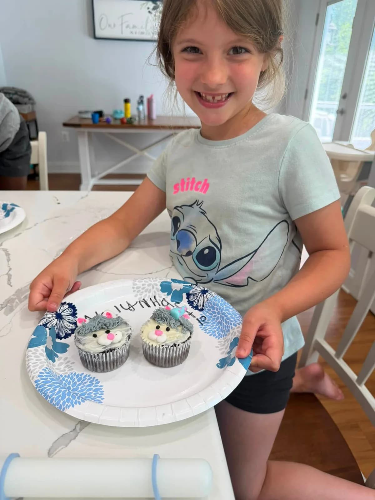 A class participant proudly displaying decorated cupcakes